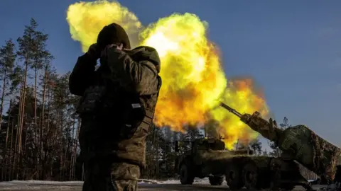 Reuters A Ukrainian soldier reacts as a howitzer fires on Russian positions in eastern Ukraine. Photo: December 2023