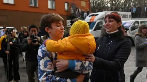 SERGEI CHUZAVKOV/AFP A mother is reunited with her son in Kyiv in March 2023