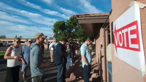 AFP Voters wait in line in front of a polling station to cast their ballots in the US presidential election in Scottsdale, Arizona on 8 November 2016