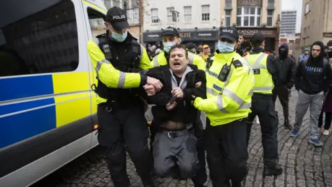 Getty Images Police arrest a man at the anti-lockdown protest in Bristol