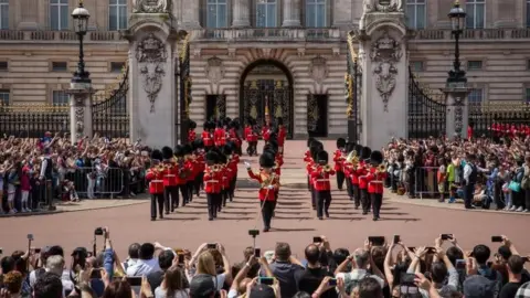 Getty Images Tourists watching the changing of the guard outside Buckingham Palace