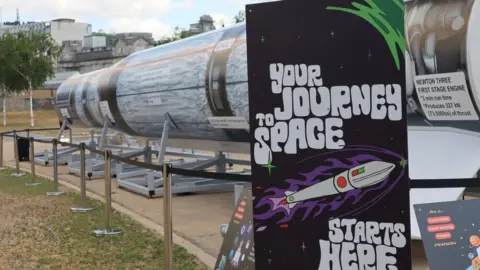 UK Space Agency A poster that reads "your journey to space starts here" in front of a model rocket