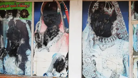 Getty Images Large photos of women on the doors of beauty salons were covered up after the Taliban took control across the country