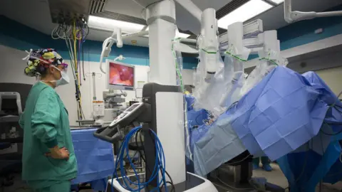 Getty Images A registered nurse watches as a robot is docked before prostate removal surgery at Maine Medical Center.