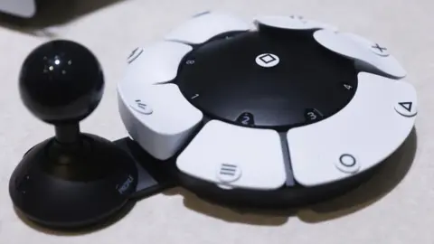 Getty Images The Access Controller looks like a circle with buttons on it and a joystick