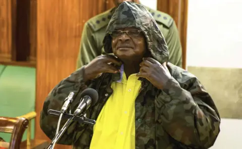 AFP Mr Museveni wears a jacket with a hoodie in parliament