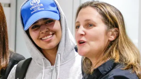 Reuters Rafah Mohammed al-Qanun is met at Toronto airport by Canadian Foreign Minister Chrystia Freeland (12 January 2019)