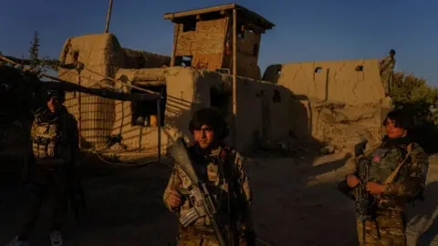 Getty Images Hazrat Bilal, 24, center, and other Afghan National Police officers patrol areas of the road heading towards the Panjwai district outside of Kandahar, Afghanistan, on Sunday Oct. 25, 2020