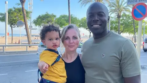 Dacres family Group picture of Addy, Jodie and Gavin on a street with trees and blue sky in the background