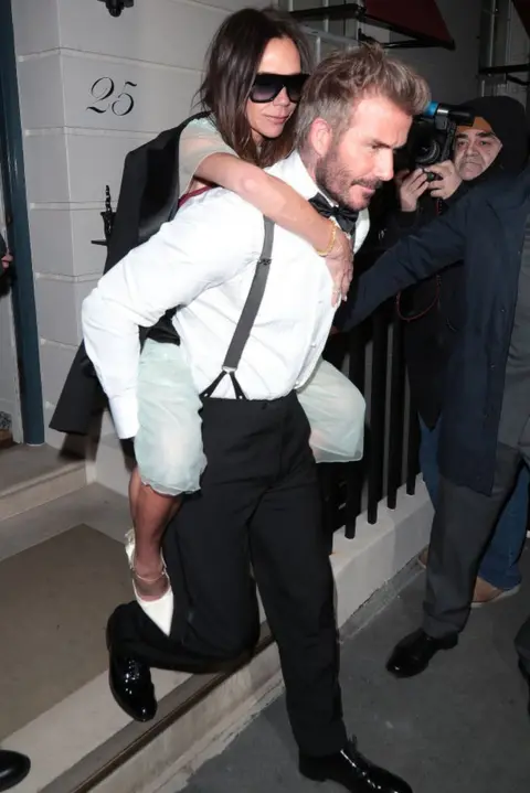 Getty Images David Beckham carrying Victoria out of the party