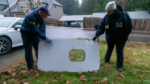 NTSB National Transportation Safety Board agents with the recovered door plug