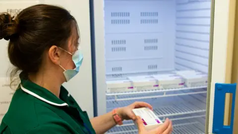 Government of Jersey Nurse placing vaccine boxes in fridge