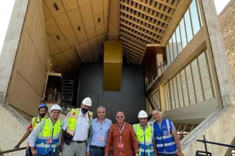 Egyptian Ministry of Tourism and Antiquity Egyptian experts and workers pose in front of the Great Boat of King Khufu