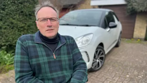 Steve Hubbard Andrew Miller in front of a white car