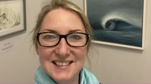 Clare Payne Clare Payne next to a painting