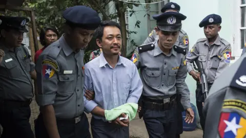 AFP Kyaw Min Swe (C), editor-in-chief of The Voice Daily newspaper, arrives to hear the Bahan township court for the third trial in Yangon on June 16, 2017