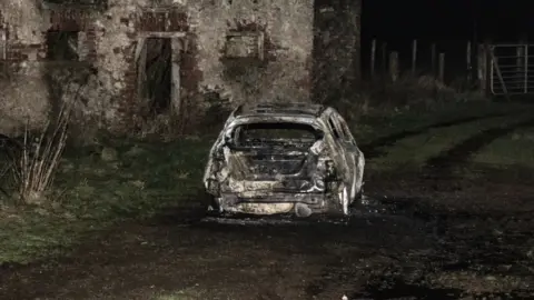 Jason McCartan A burnt-out car at Racolpa Road outside Omagh