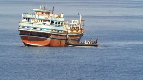 BBC/Maarten Lernout Dhow is seen with Navy boat about to board