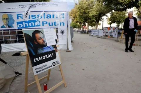 Getty Images A poster bearing a portrait of Georgian national Zelimahn Khangoshvili, who was shot dead by an alleged Russian operative in Berlin's Kleiner Tiergarten Park in August 2019