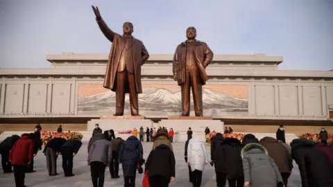 Getty Images People visit the statues of late North Korean leaders Kim Il Sung and Kim Jong Il on the occasion of the 79th birth anniversary of Kim Jong Il, known as the 'Day of the Shining Star', at Mansu Hill in Pyongyang on February 16, 2021.