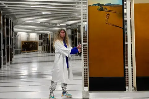 BBC Ina Klaassen stands beside Landscape with a Girl Skipping Rope by Dalí