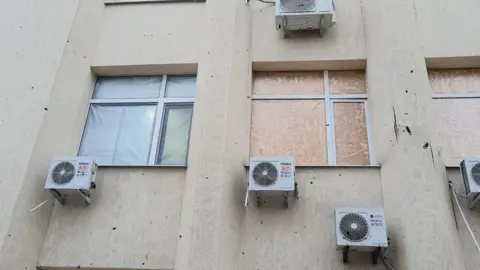 Insulate Ukraine Bullet damaged windows in Ukraine, with one repaired by Insulate Ukraine