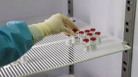 Reuters A medical worker in Italy holds a vial of the Oxford-AstraZeneca vaccine