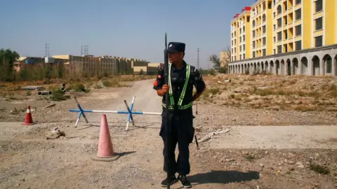 Reuters Chinese police officer outside what is formally known as a "vocational educational facility" in Xinjiang, China (file pic)