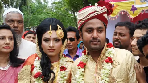 Ujjwal Masud Tariqul Islam (right) and bride Khadiza Akter Khushi pose for a photo during their wedding in Meherpur
