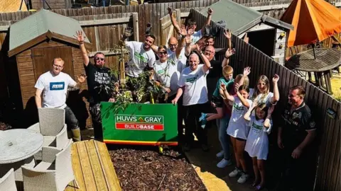 a group of people stand by the completed garden