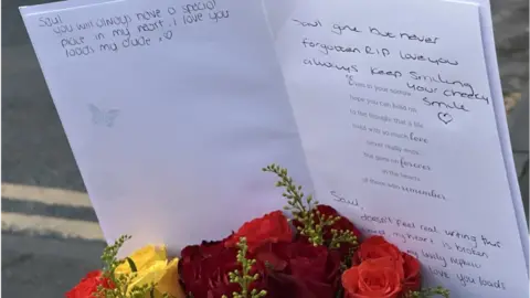 Flowers and sympathy card left at crash scene
