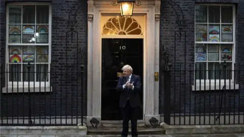 EPA British Prime Minister Boris Johnson takes part during the "Clap for our Carers" campaign in support of Britain"s National Health Service (NHS) in front of 10 Downing Street in central London