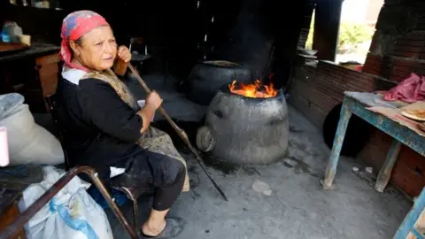Reuters A woman bakes bread, locally known as "Tabouna", using a traditional mud oven in Grombalia, Tunisia April 22, 2018.