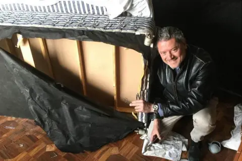 BBC Vasileios Vasileiou next to the bed he hid inside while Taliban gunmen operated from his room