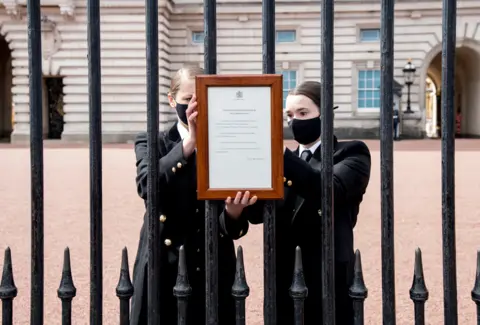 Ian West / Pool via Reuters A sign announcing the death of the Britain's Prince Philip, Duke of Edinburgh is placed on the gates of Buckingham Palace