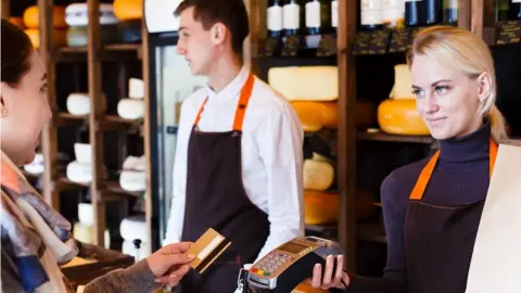 Getty Images Customer paying for cheese