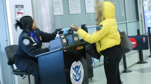 AFP People being checked at TSA screening