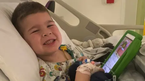 Shaun Oscar smiling in a hospital bed