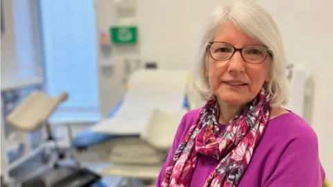 BBC Christine Rickets sitting looking at the camera wearing a lilac jumper