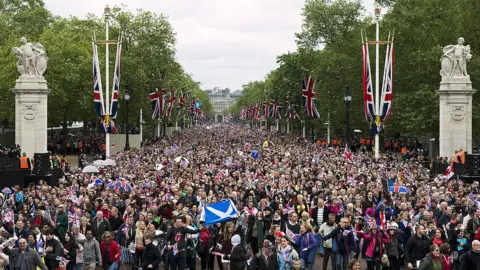 Getty Images Huge crowds cheering with Britain's Union flags march down the Mall towards Buckingham Palace to celebrate the Queen's Diamond Jubilee