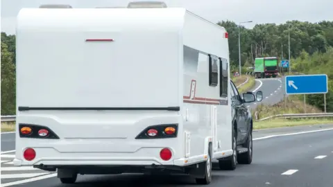 Getty Images A caravan being towed by another vehicle, on the motorway.