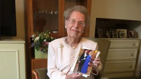 Audrey holding a birthday card from the King and Queen