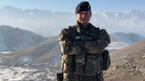 Yvette Kemp Yvette Kemp standing on a mountain in her military uniform