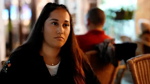 a young woman sitting in a restaurant/bar