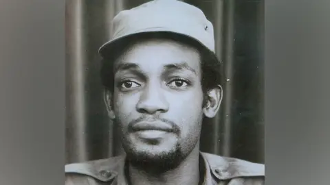 Van Dunem family Black and white portrait of a man in a cap