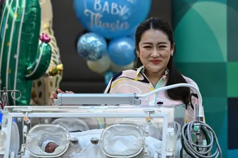 Getty Images Paetongtarn Shinawatra presents her newborn son in an incubator on 3 May 2023.