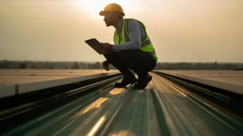 Getty Images Engineer checking solar panels