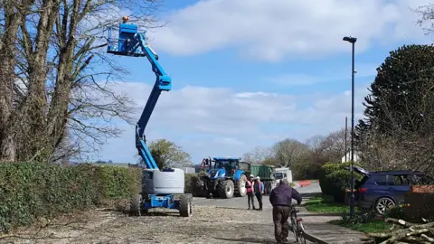 PA Media/Andrew Mason The cherry-picker cutting the trees in Church Fenton