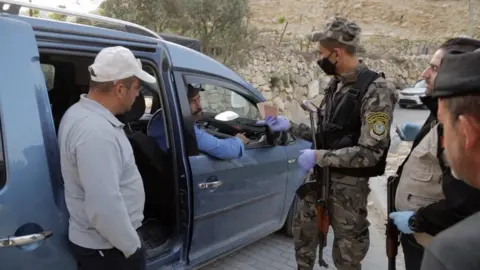 BBC Palestinian security forces search a car near the West Bank town of Hebron to prevent workers crossing illegally into Israel