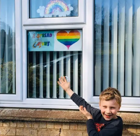 Angela Jane Ruthven Harrison points to rainbow in wndow